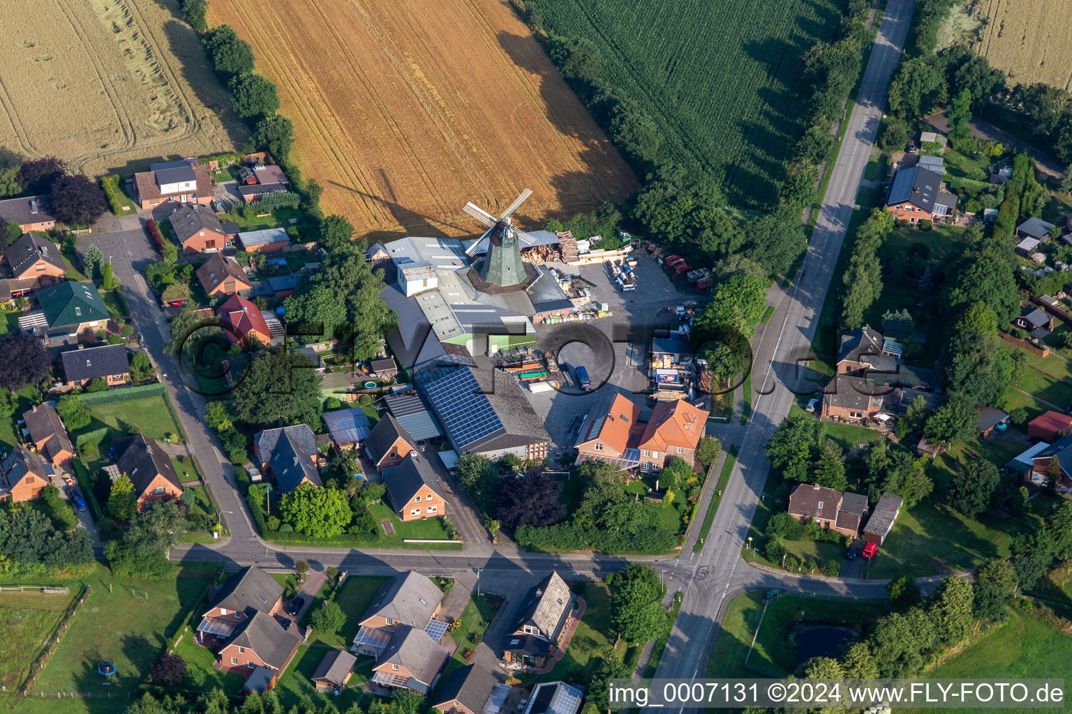 Historic windmill on a farm homestead of Hass Landhandel on the edge of cultivated fields in Suederhastedt in the state Schleswig-Holstein, Germany