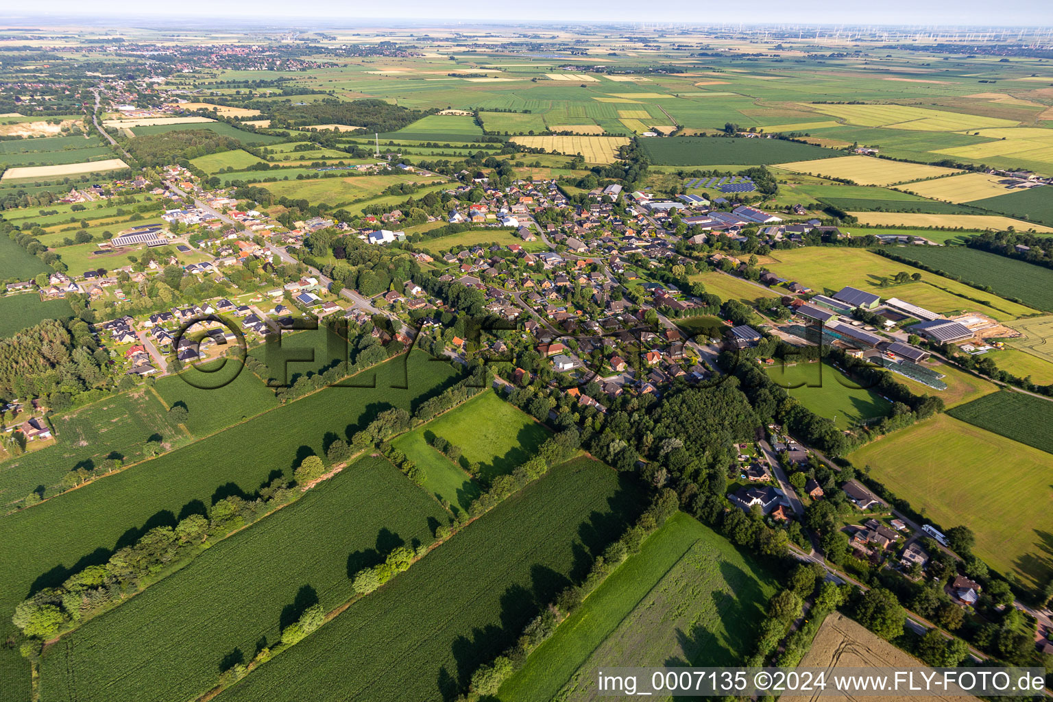 Agricultural land and field boundaries surround the settlement area of the village in Bargenstedt in the state Schleswig-Holstein, Germany