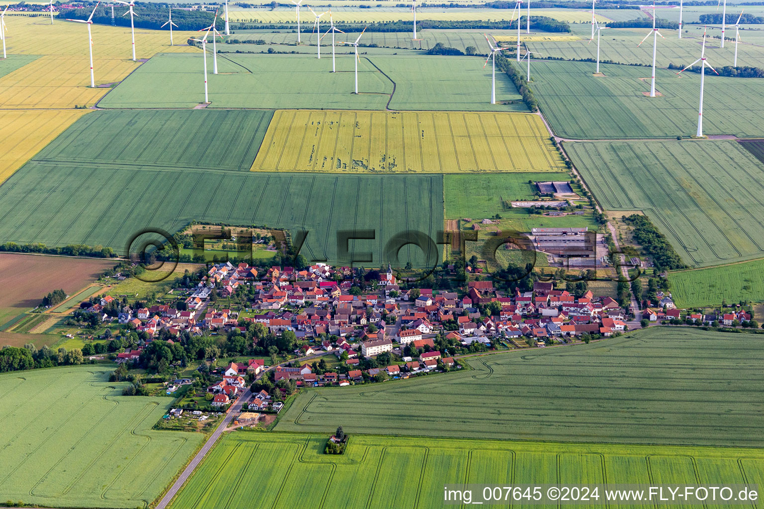 Wind turbines of a wind power plant on agricultural land and fields on the edge of the settlement area of the village in Hochheim in the state Thuringia, Germany