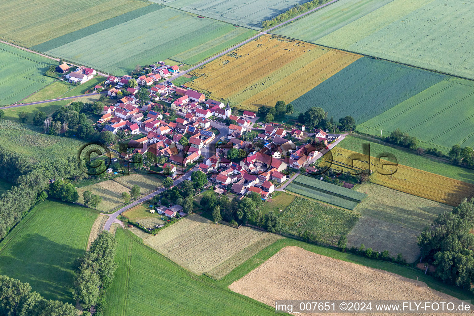 Aerial photograpy of Agricultural land and field boundaries surround the settlement area of the village in Hausen in the state Thuringia, Germany