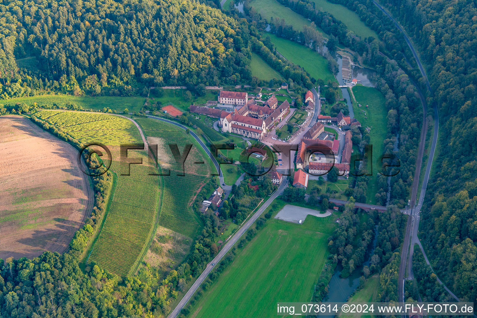 Aerial view of Complex of buildings of the monastery Bronnbach with garden and Church Mariae Himmelfahrt in Wertheim in the state Baden-Wurttemberg, Germany