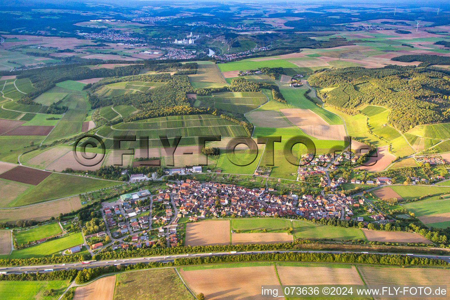 Village - view behind motorway A3 on the edge of agricultural fields and farmland in the district Dertingen in Wertheim in the state Baden-Wurttemberg