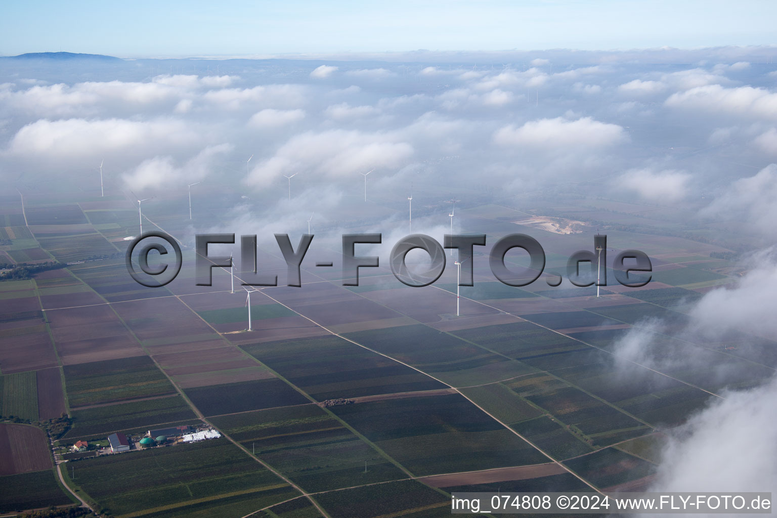 Wind energy installations embedded under a cloud layer on a field near Worms in the state Rhineland-Palatinate