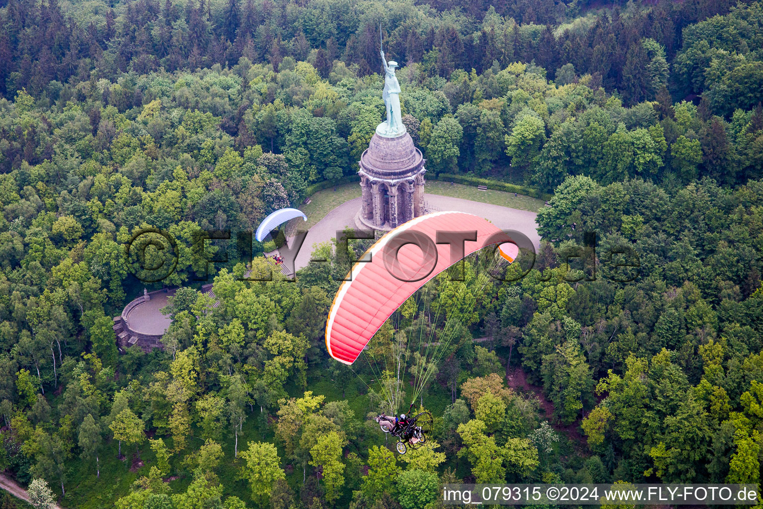 Tourist attraction of the historic monument Hermannsdenkmal with paragliders in Detmold in the state North Rhine-Westphalia