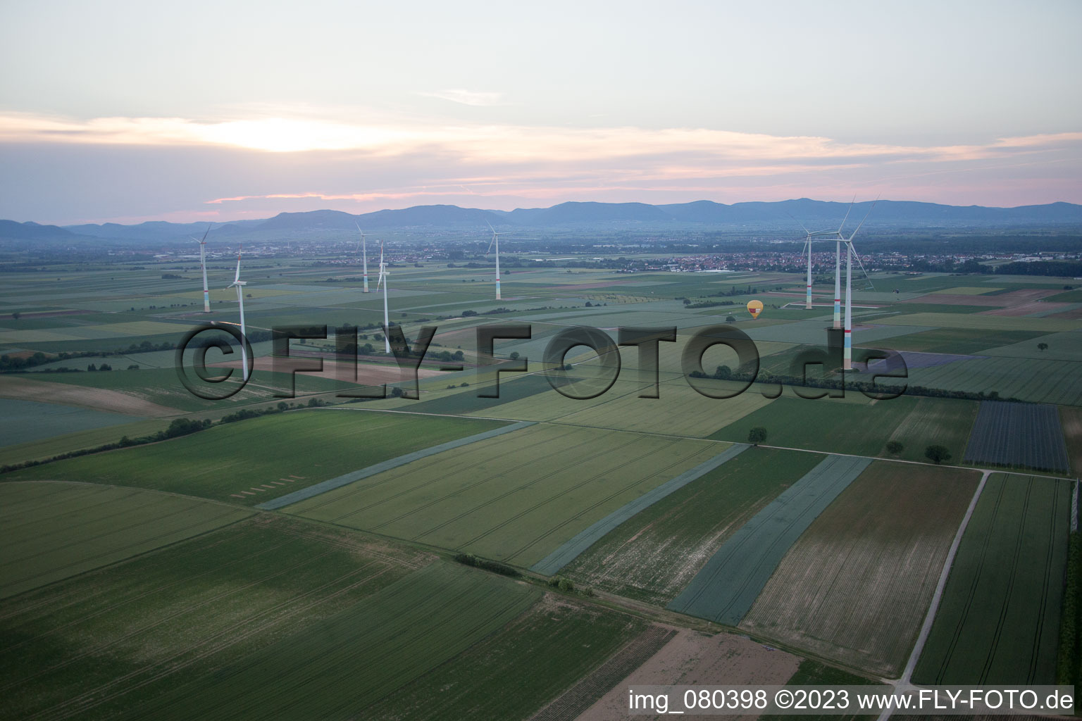 Hot air balloon between wind turbines in the district Herxheim in Herxheim bei Landau/Pfalz in the state Rhineland-Palatinate, Germany