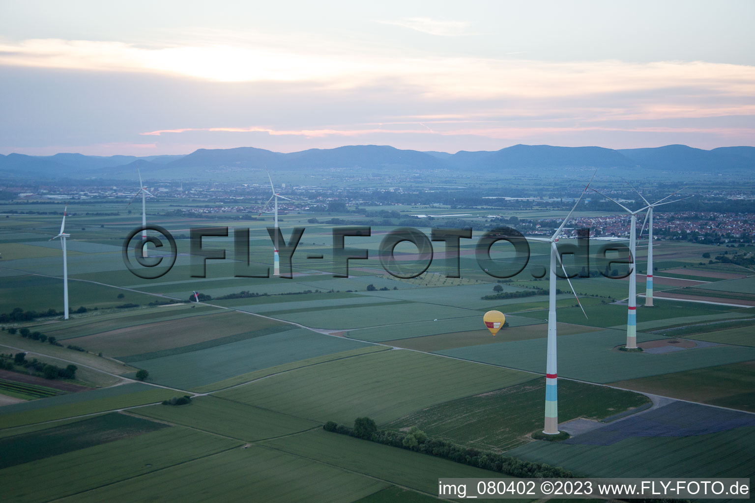 Hot air balloon between wind turbines in Offenbach an der Queich in the state Rhineland-Palatinate, Germany