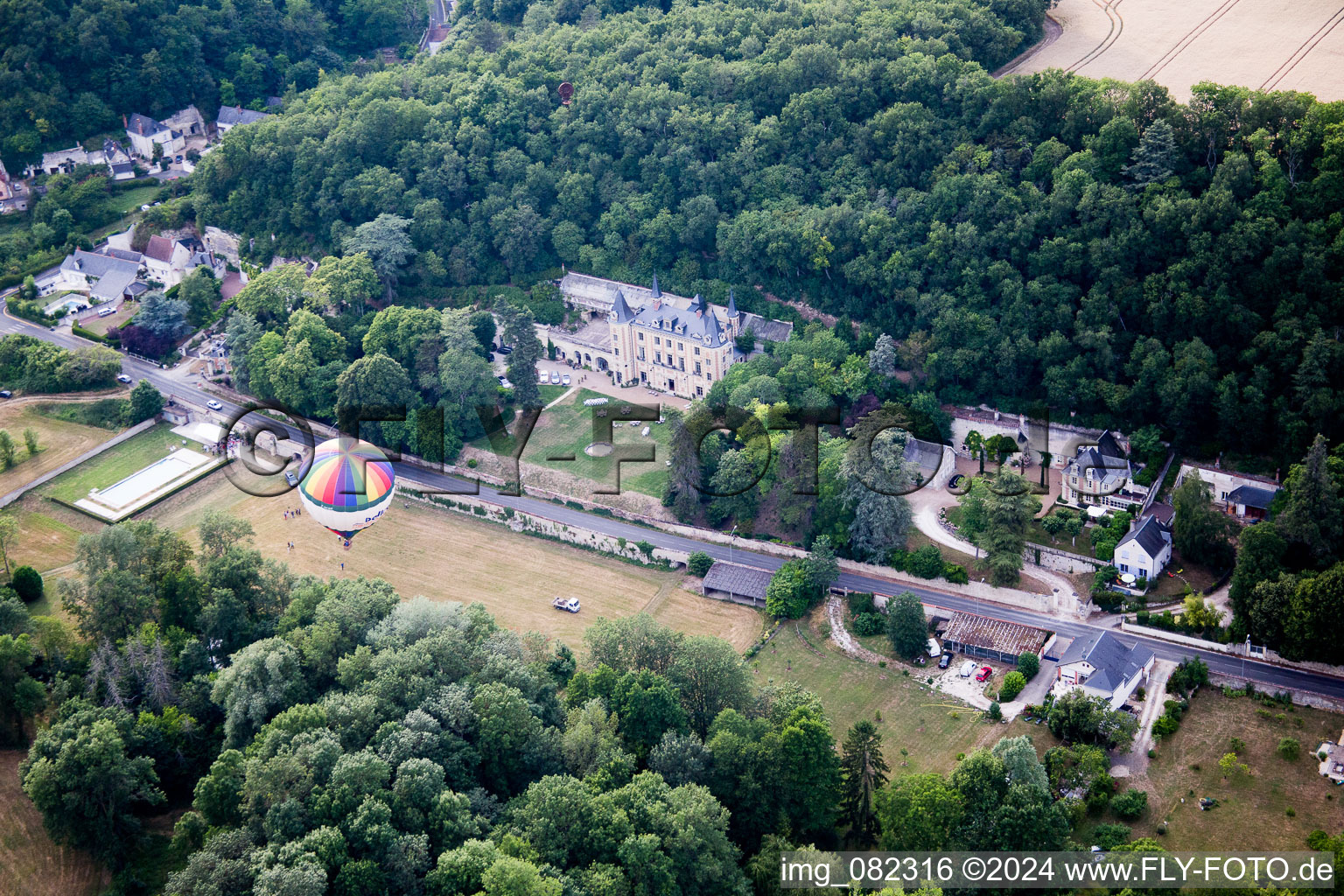 Hot air balloon launch in front of Chateau de Perreux in Nazelles-Negron in Centre-Val de Loire, France from above