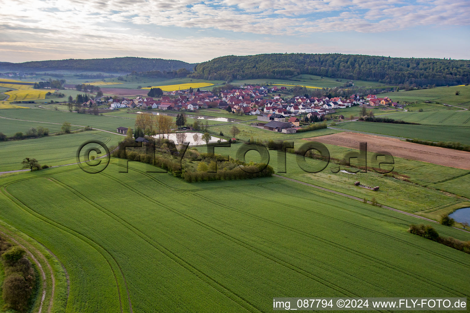 Aerial view of Village - view on the edge of agricultural fields and farmland in Rauhenebrach in the state Bavaria, Germany