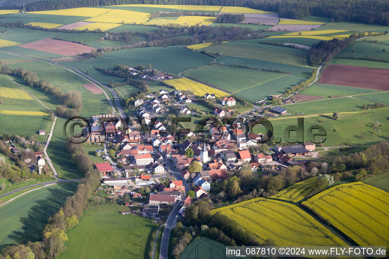 Village - view on the edge of agricultural fields and farmland in the district Falsbrunn in Rauhenebrach in the state Bavaria, Germany