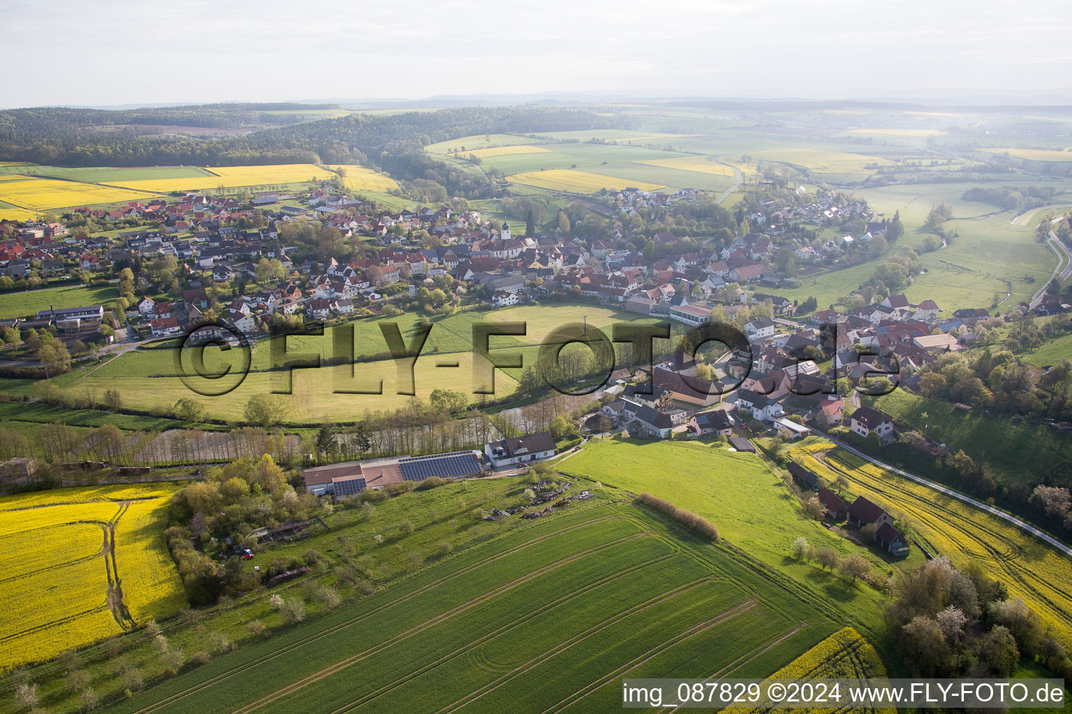 Aerial view of Village - view on the edge of agricultural fields and farmland in Schoenbrunn im Steigerwald in the state Bavaria, Germany