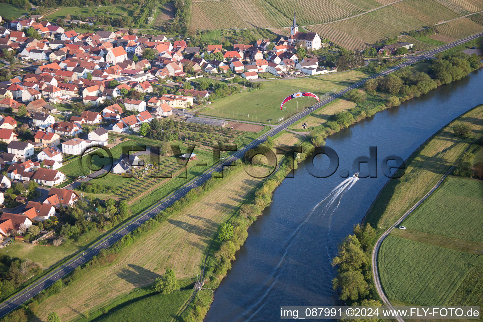 Village on the bank areas of the river Main with sport boat and paraglider in Kolitzheim in the state Bavaria