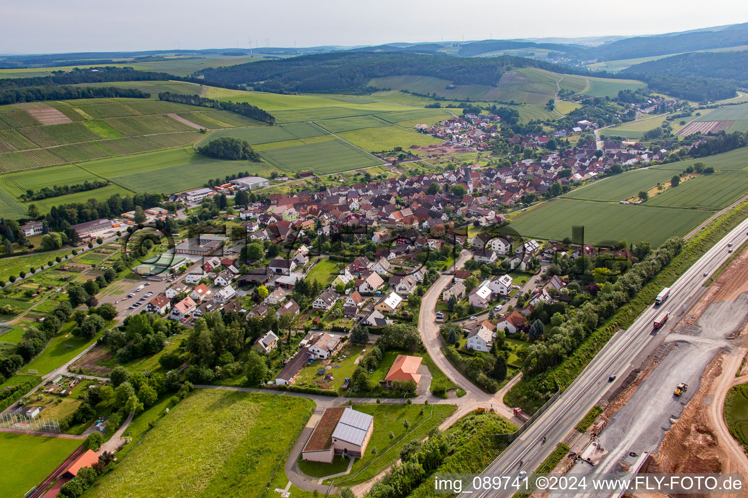 Aerial view of Village - view behind motorway A3 on the edge of agricultural fields and farmland in the district Dertingen in Wertheim in the state Baden-Wurttemberg