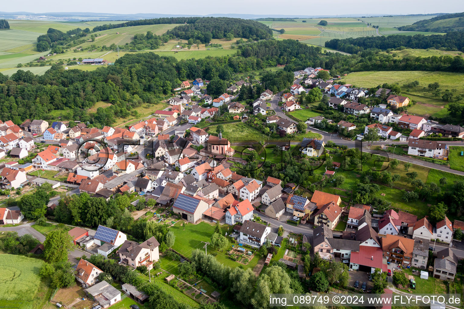 Aerial view of Village - view on the edge of agricultural fields and farmland in Wuestenzell in the state Bavaria, Germany