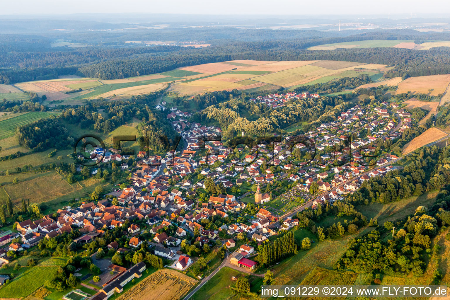 Aerial view of Village - view on the edge of agricultural fields and farmland in Sippersfeld in the state Rhineland-Palatinate, Germany