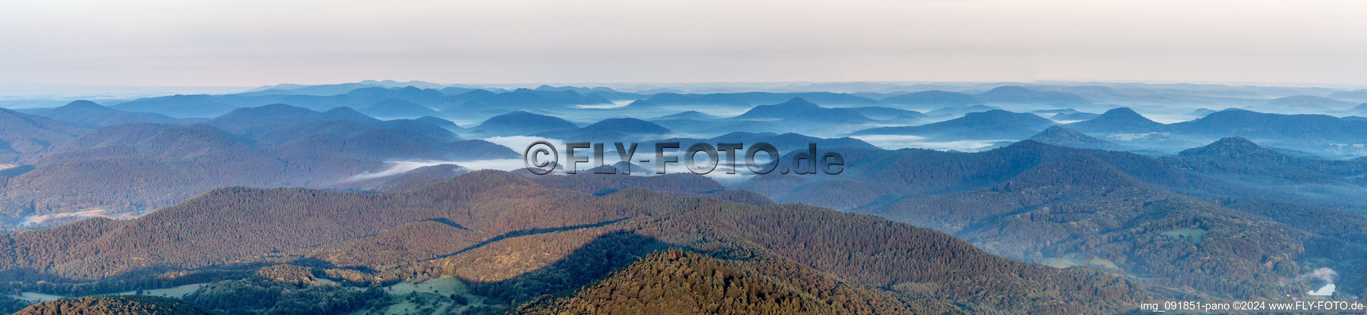 Panoramic perspective of Forest and mountain scenery of the Pfaelzerwald with valleys in morning mist in Dahn in the state Rhineland-Palatinate, Germany