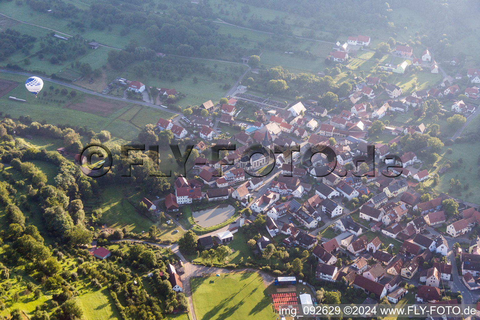 Village - view on the edge of agricultural fields and farmland in Leutenbach in the state Bavaria, Germany