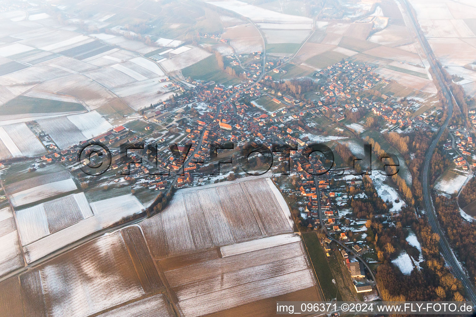 Wintry snowy Village - view on the edge of agricultural fields and farmland in Riedseltz in Grand Est, France