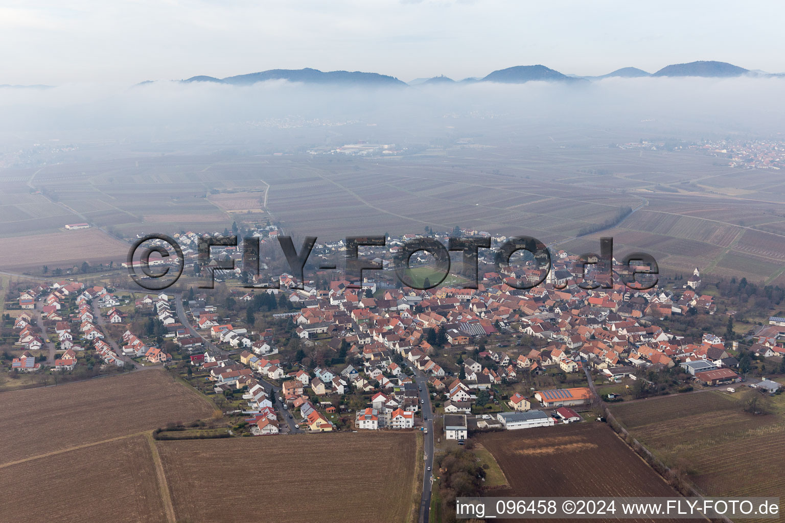 Village - view below clouds on the edge of agricultural fields and farmland in the district Moerzheim in Landau in der Pfalz in the state Rhineland-Palatinate, Germany