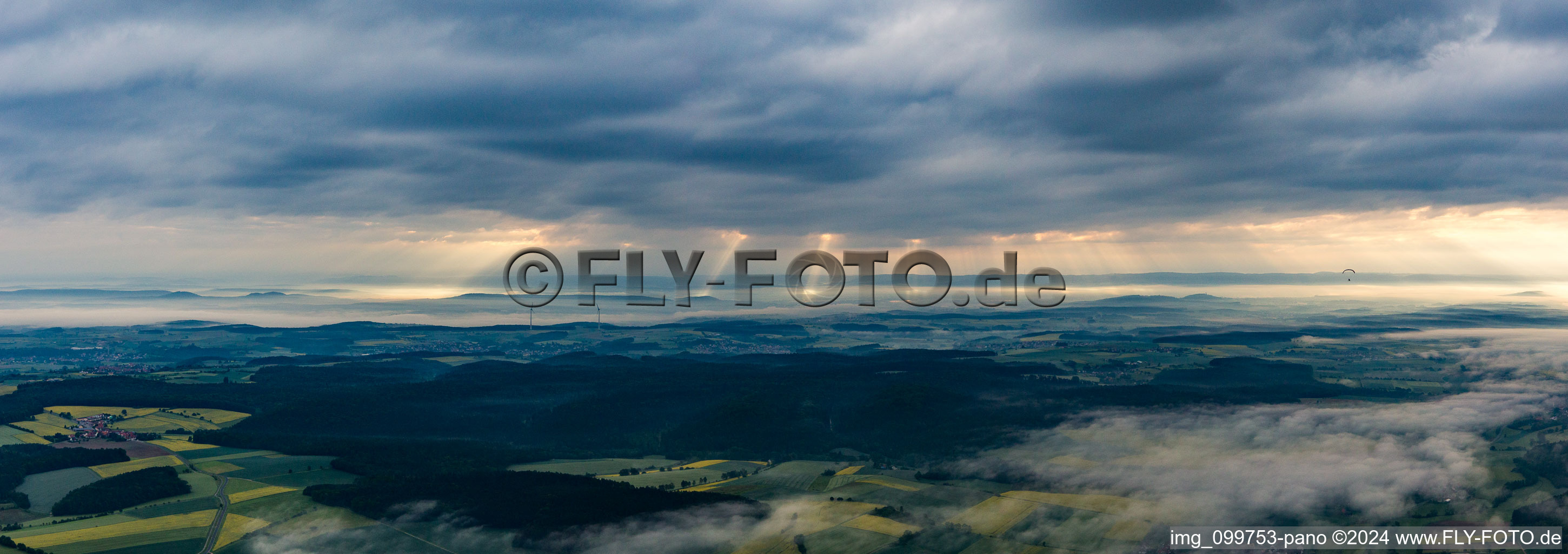 Morning sun penetrates through the clouds in the district Schönbrunn in  Steigerwald in Schönbrunn im Steigerwald in the state Bavaria, Germany