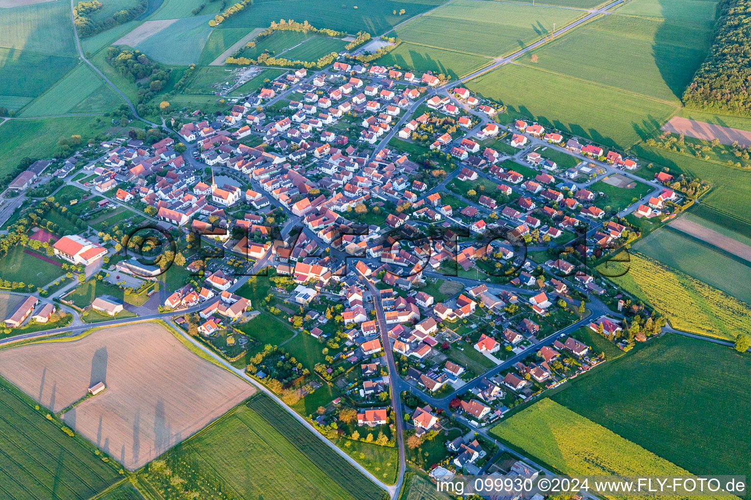 Aerial photograpy of Village - view on the edge of agricultural fields and farmland in Wasserlosen in the state Bavaria, Germany