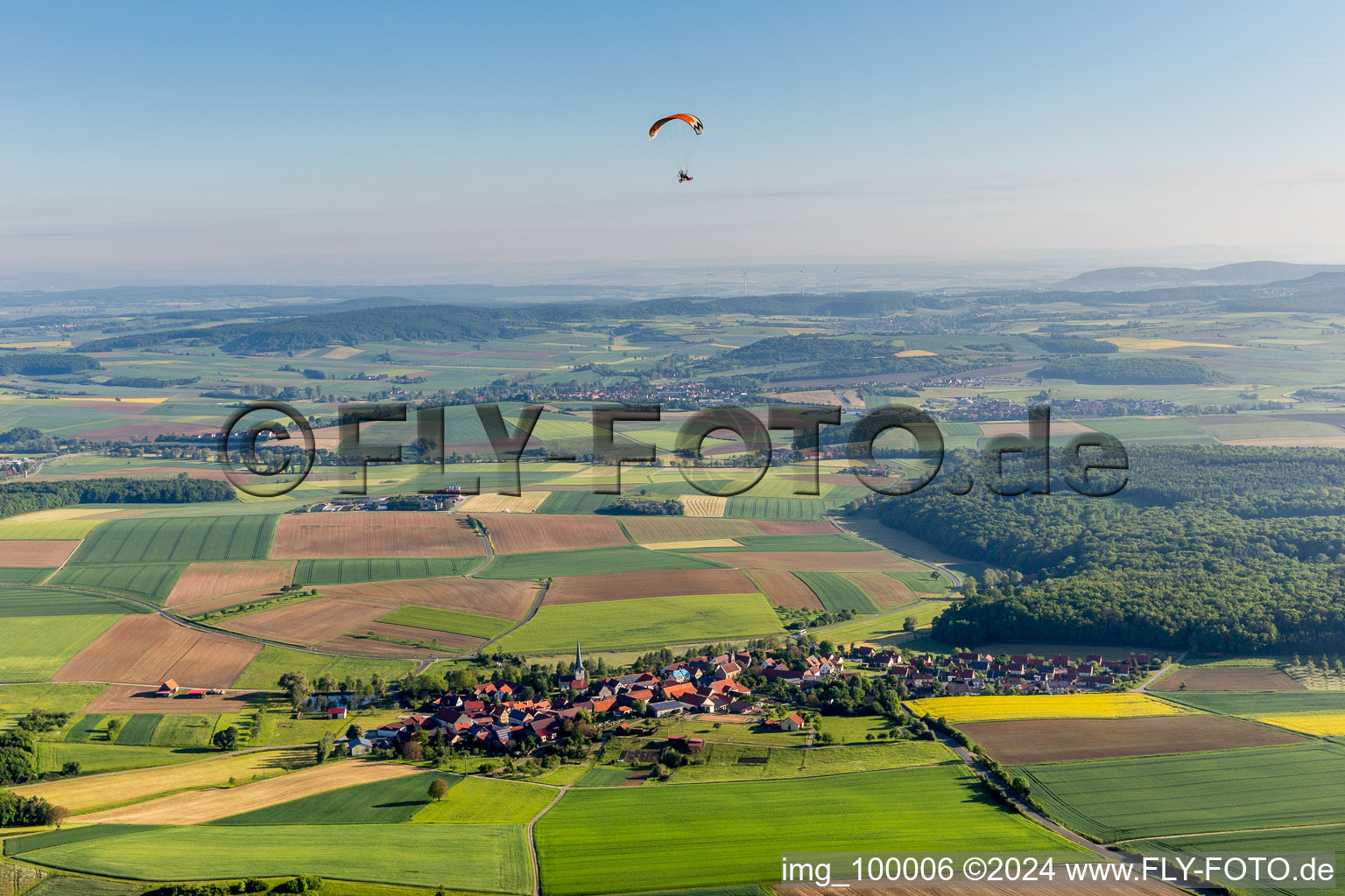 Paraglider over the village in the district Altenmünster in Stadtlauringen in the state Bavaria, Germany