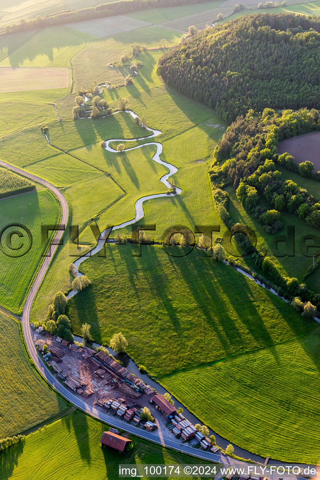 Aerial view of Meandering, serpentine curve of a river Baunach in Ebern in the state Bavaria, Germany