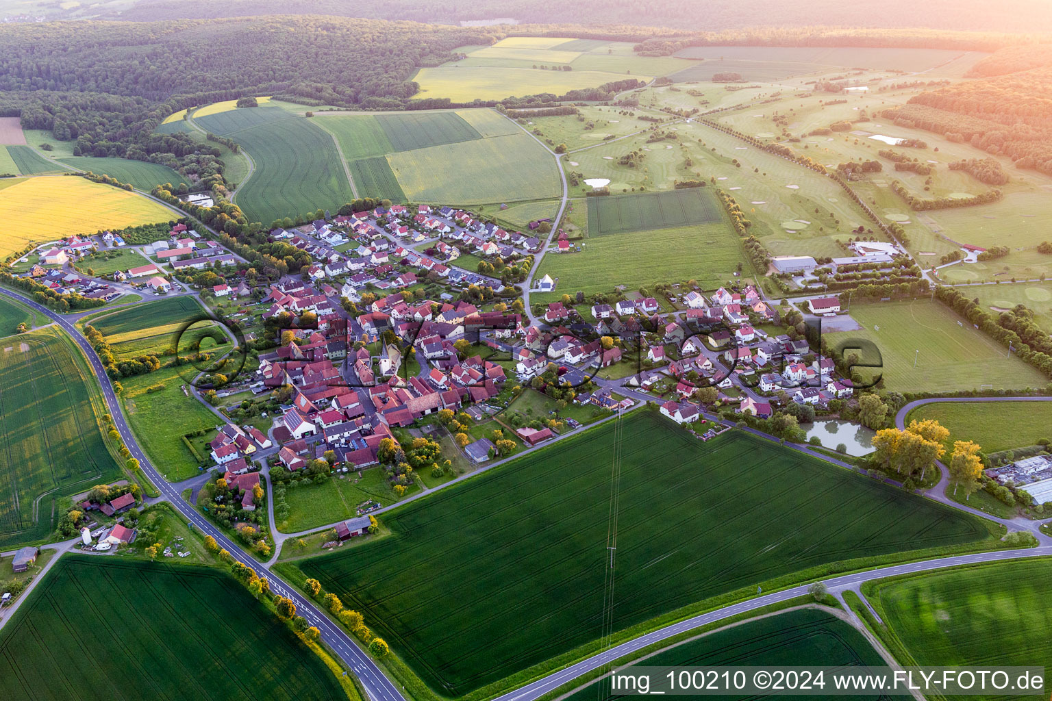 Village - view on the edge of agricultural fields and farmland in the district Loeffelsterz in Schonungen in the state Bavaria, Germany