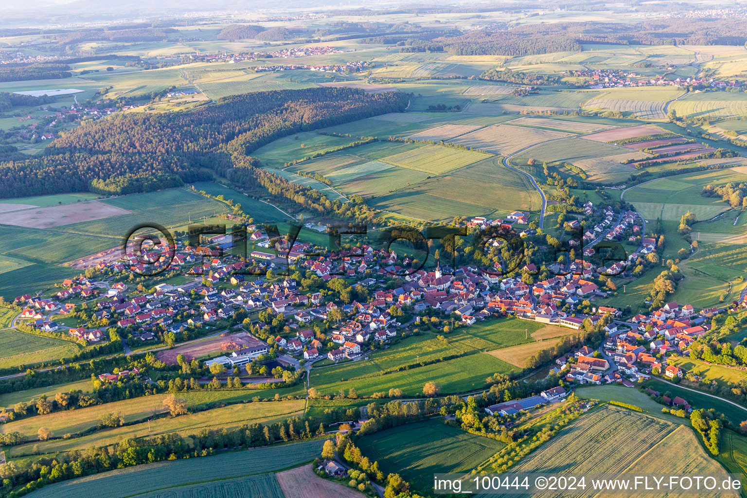 Aerial view of Village - view on the edge of agricultural fields and farmland in Schoenbrunn im Steigerwald in the state Bavaria, Germany