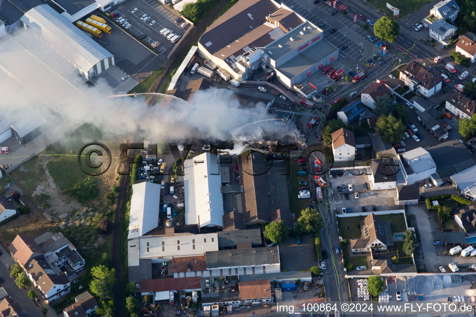 Oblique view of Smoke and flames during the fire fighting to fire of a storage all for antiqities in the Werkstrasse in Speyer in the state Rhineland-Palatinate, Germany