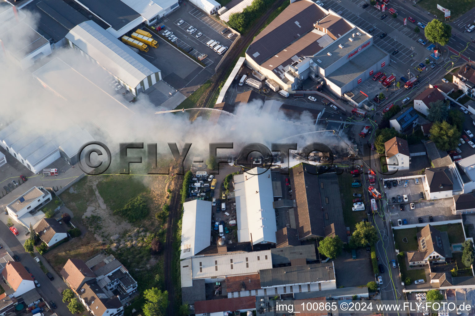 Smoke and flames during the fire fighting to fire of a storage all for antiqities in the Werkstrasse in Speyer in the state Rhineland-Palatinate, Germany from above