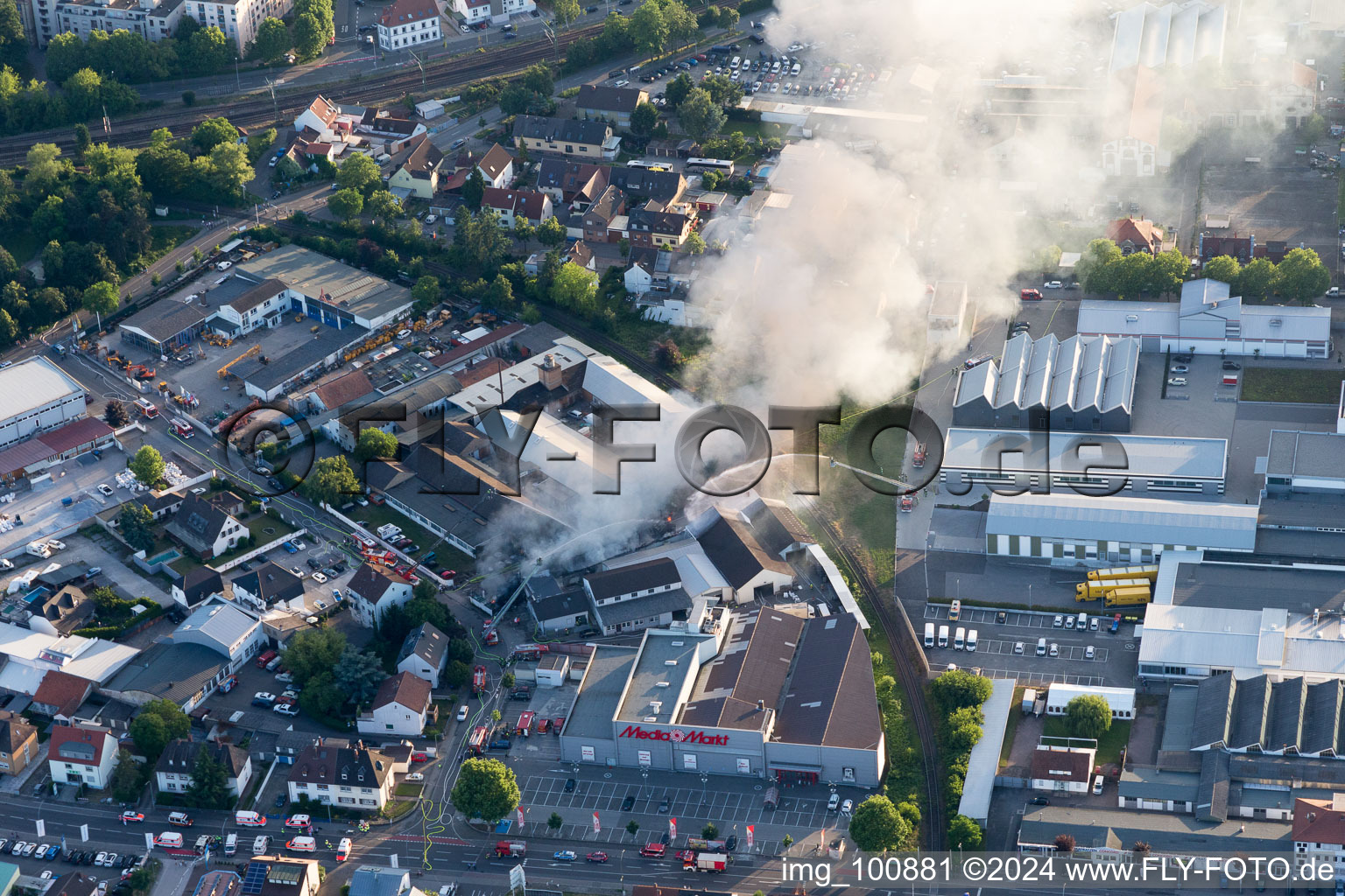 Drone image of Smoke and flames during the fire fighting to fire of a storage all for antiqities in the Werkstrasse in Speyer in the state Rhineland-Palatinate, Germany