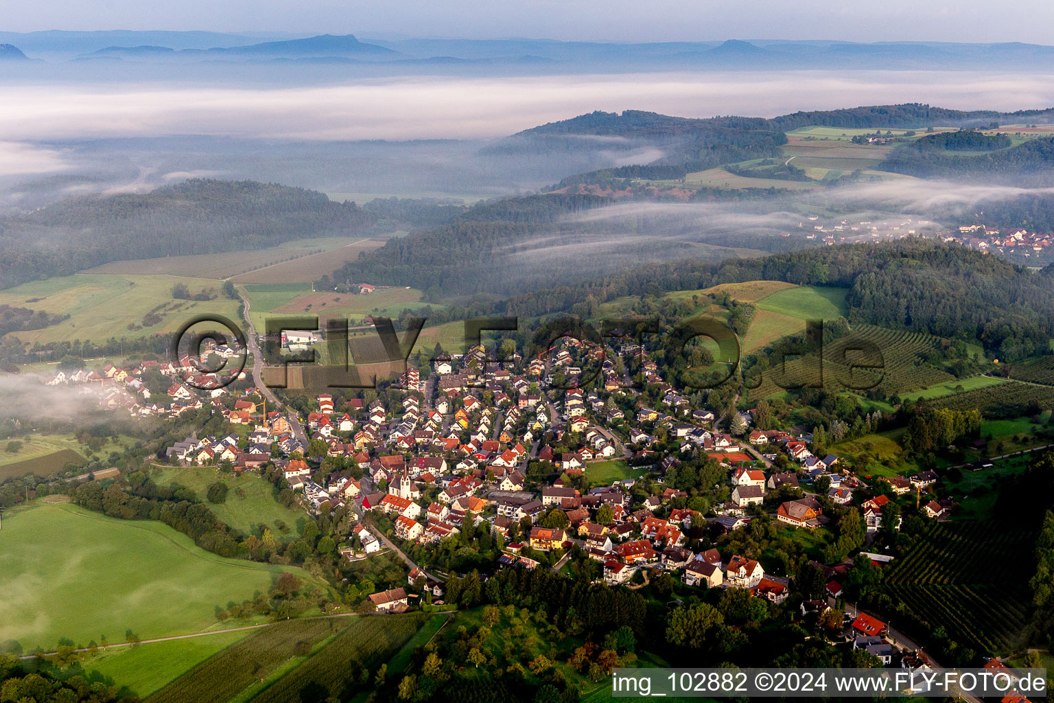 The Lake of Constance hidden by morning fog over Village - view on the edge of agricultural fields and farmland in the district Moeggingen in Radolfzell am Bodensee in the state Baden-Wurttemberg, Germany