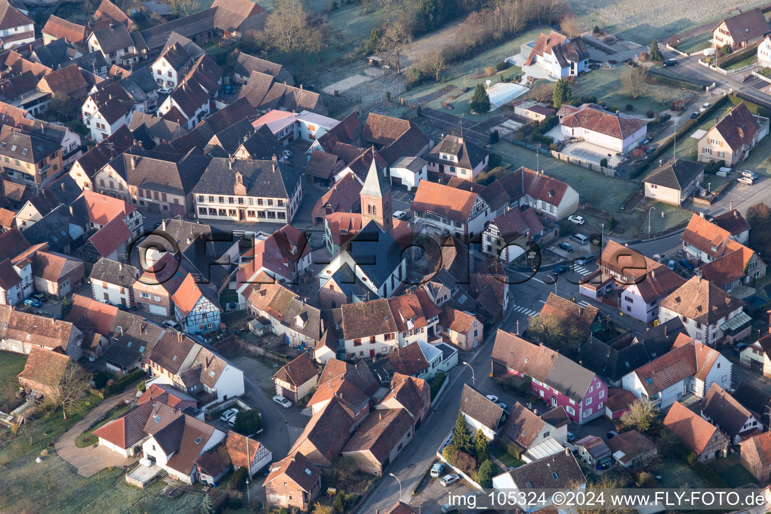 Aerial photograpy of Protestantic Church building in the center of a circle of houses in the village of in Dossenheim-sur-Zinsel in Grand Est, France