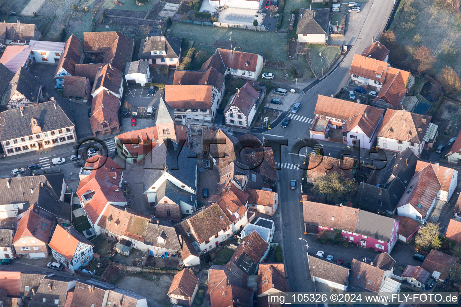 Protestantic Church building in the center of a circle of houses in the village of in Dossenheim-sur-Zinsel in Grand Est, France from above