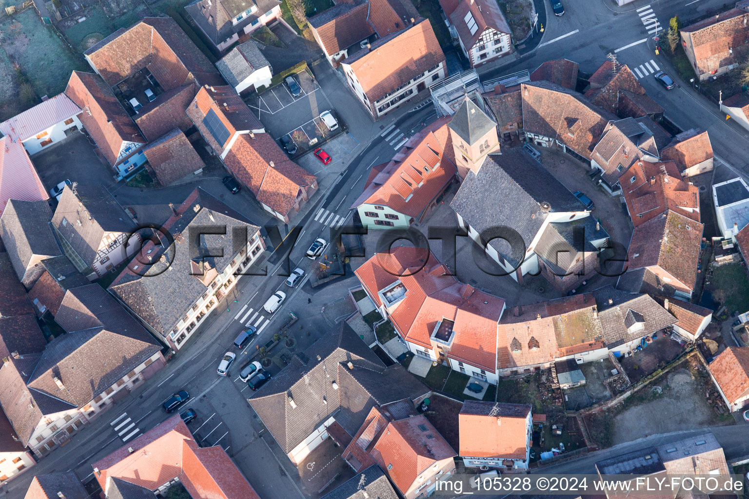 Protestantic Church building in the center of a circle of houses in the village of in Dossenheim-sur-Zinsel in Grand Est, France seen from above