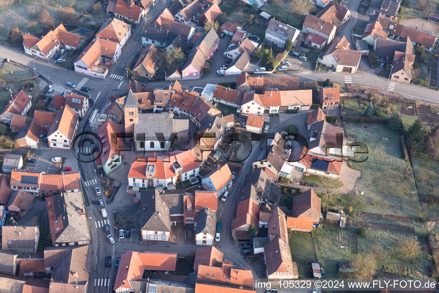 Protestantic Church building in the center of a circle of houses in the village of in Dossenheim-sur-Zinsel in Grand Est, France from the plane