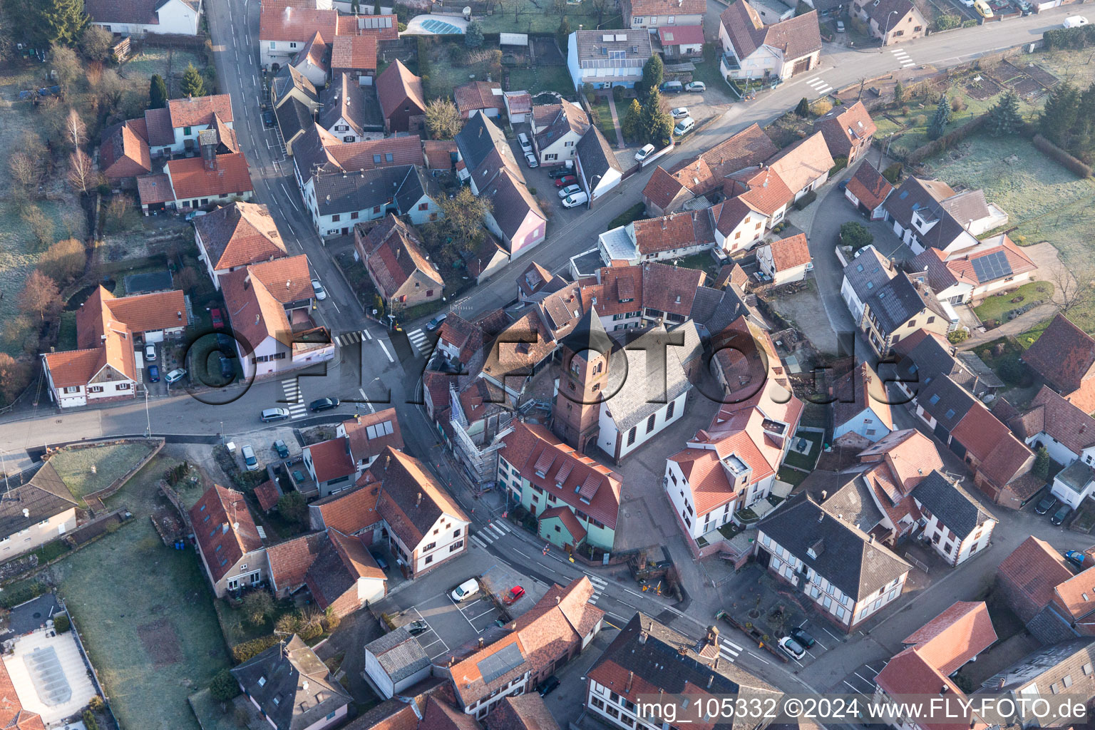 Drone recording of Protestantic Church building in the center of a circle of houses in the village of in Dossenheim-sur-Zinsel in Grand Est, France