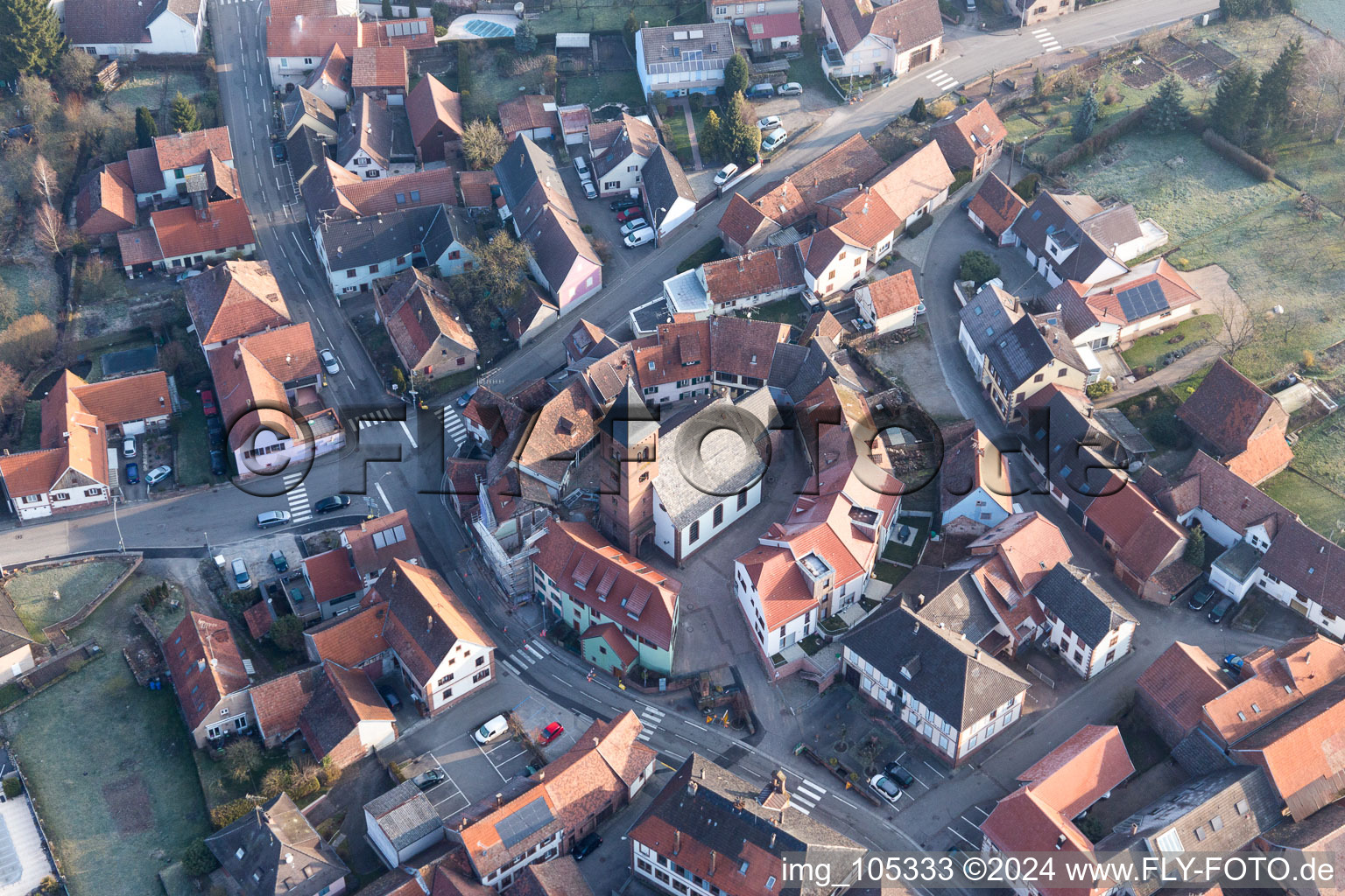 Drone image of Protestantic Church building in the center of a circle of houses in the village of in Dossenheim-sur-Zinsel in Grand Est, France