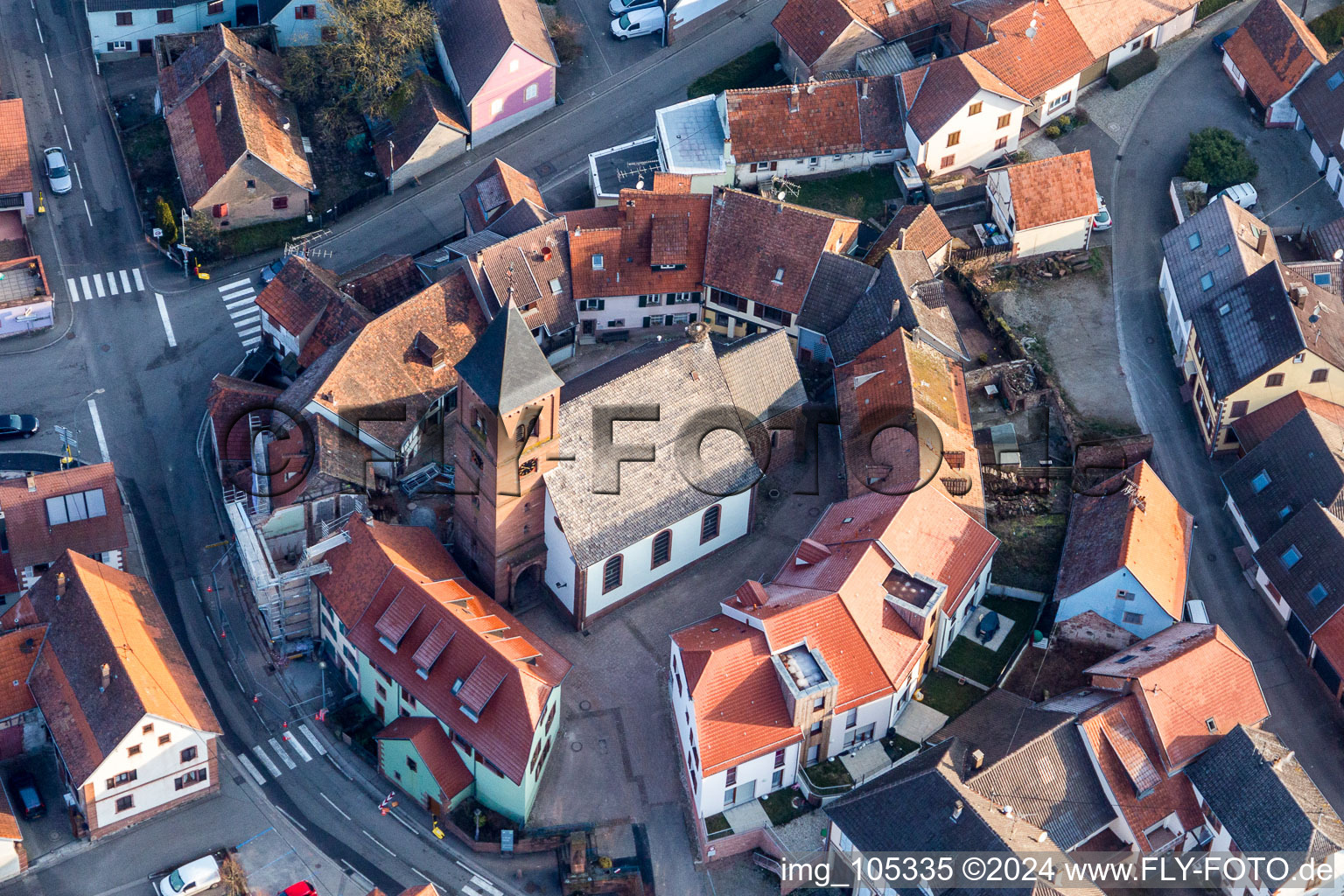 Church building of St. Leonhard surrounded by a circle of houses in the village of in Dossenheim-sur-Zinsel in Grand Est, France