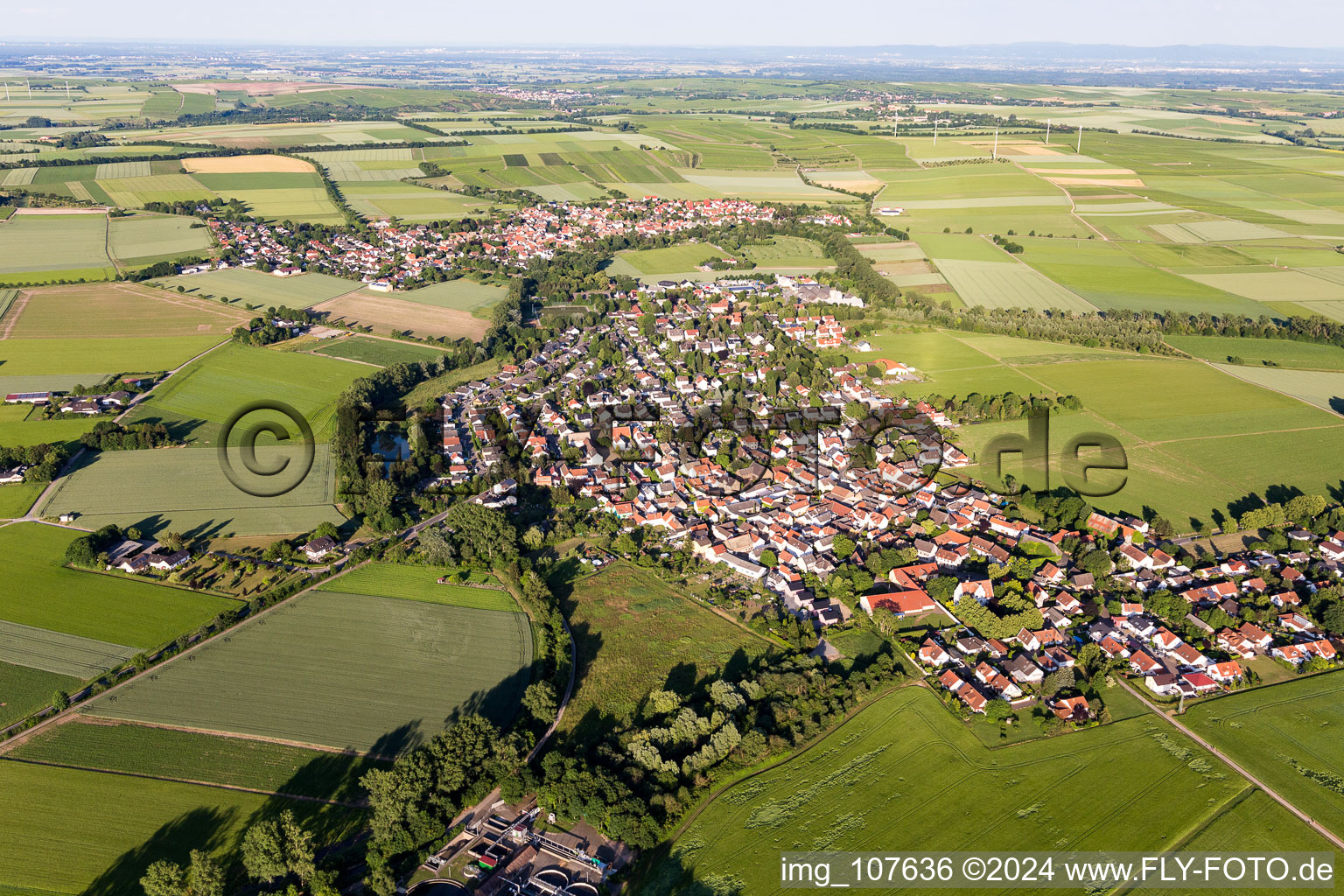 Agricultural land and field borders surround the settlement area of the village in Hahnheim in the state Rhineland-Palatinate, Germany