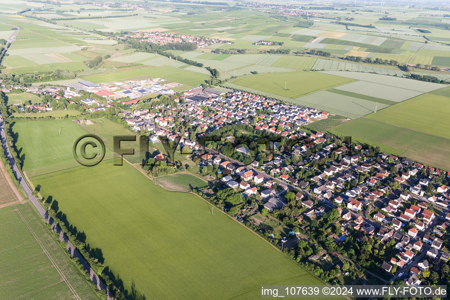 Agricultural land and field borders surround the settlement area of the village in Undenheim in the state Rhineland-Palatinate, Germany seen from above