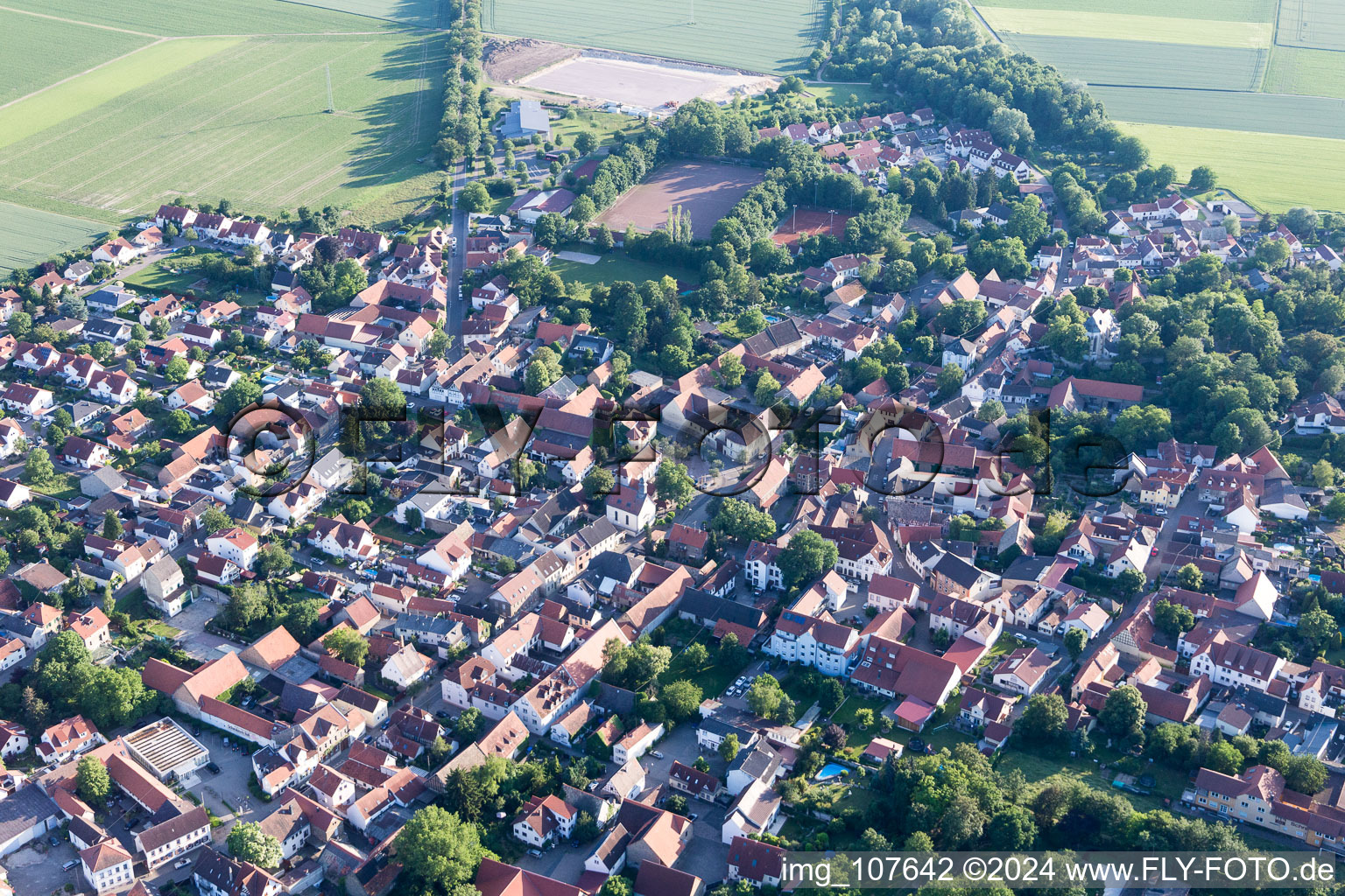 Agricultural land and field borders surround the settlement area of the village in Undenheim in the state Rhineland-Palatinate, Germany viewn from the air