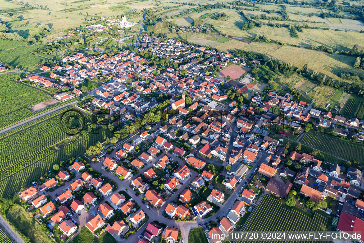 Agricultural land and field borders surround the settlement area of the village in Erpolzheim in the state Rhineland-Palatinate, Germany from above