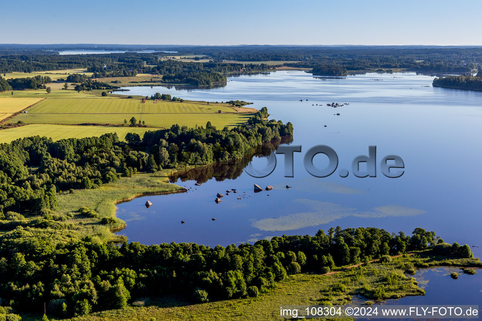 Forests on the bay of swamp coloured Asnen lake near Hunna in Smaland in Kronobergs laen, Sweden