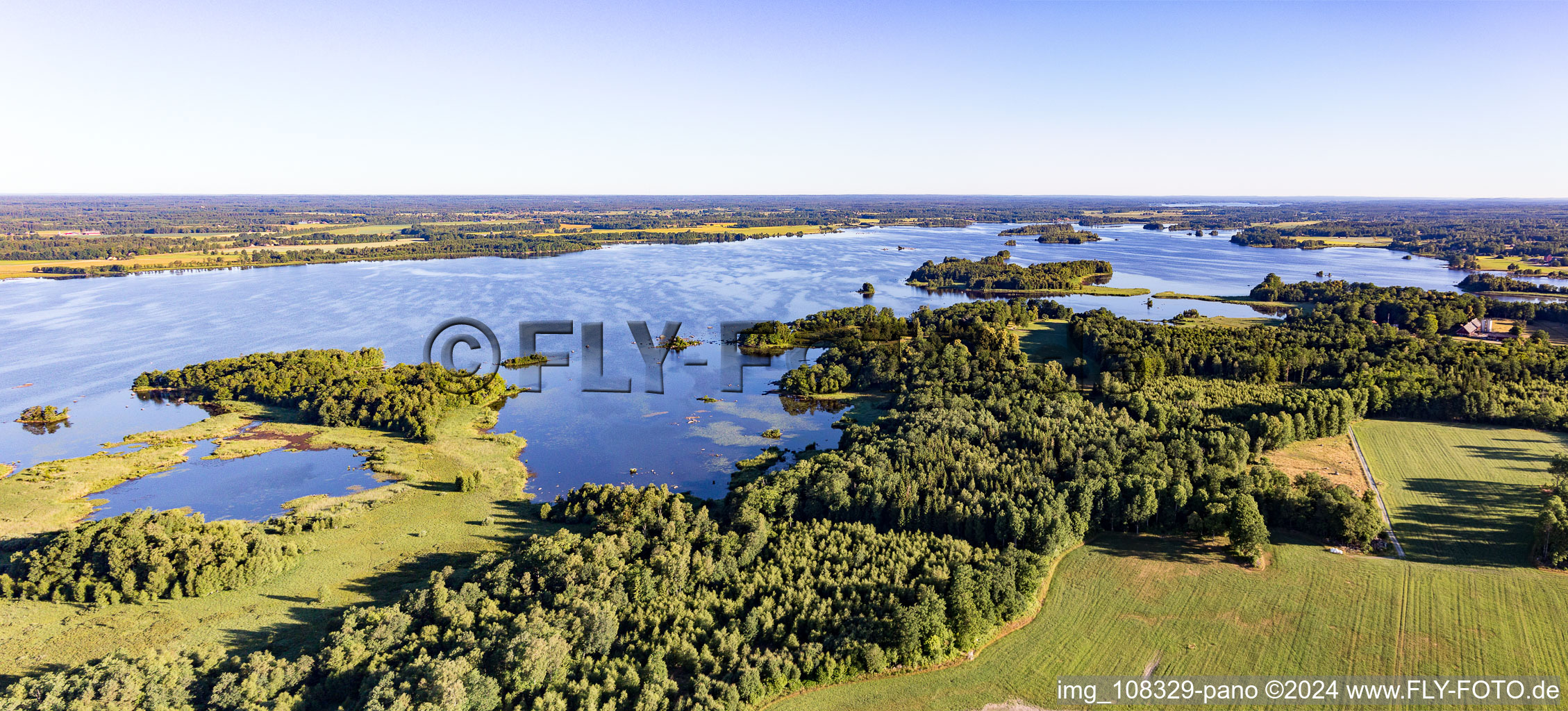 Forests on the bay of swamp coloured Asnen lake near Vrankunge in Smaland in Kronobergs laen, Sweden