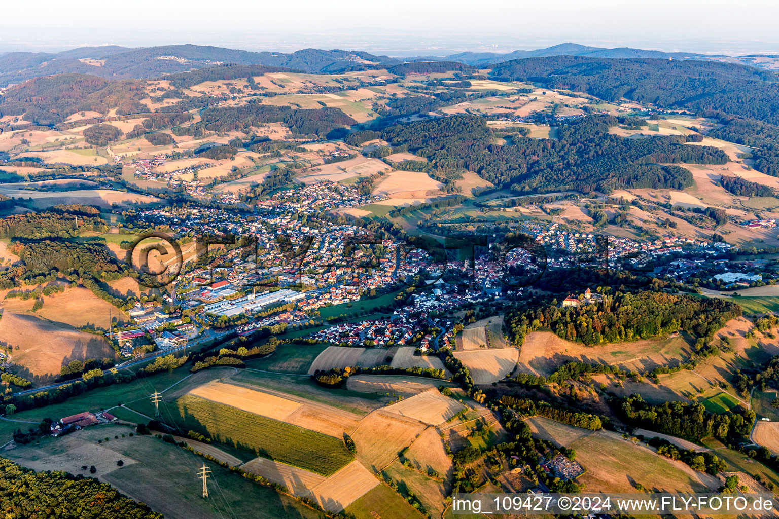 Location view of the streets and houses of residential areas in the valley landscape surrounded by mountains in Reichelsheim (Odenwald) in the state Hesse, Germany