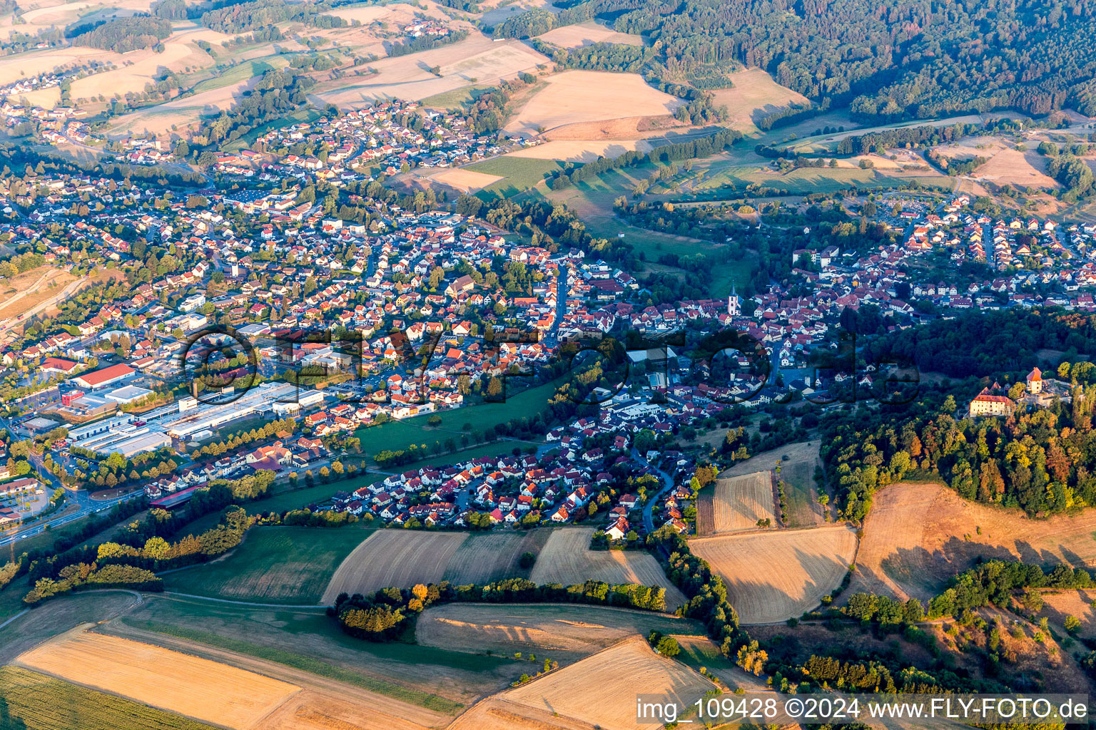 Aerial view of Location view of the streets and houses of residential areas in the valley landscape surrounded by mountains in Reichelsheim (Odenwald) in the state Hesse, Germany