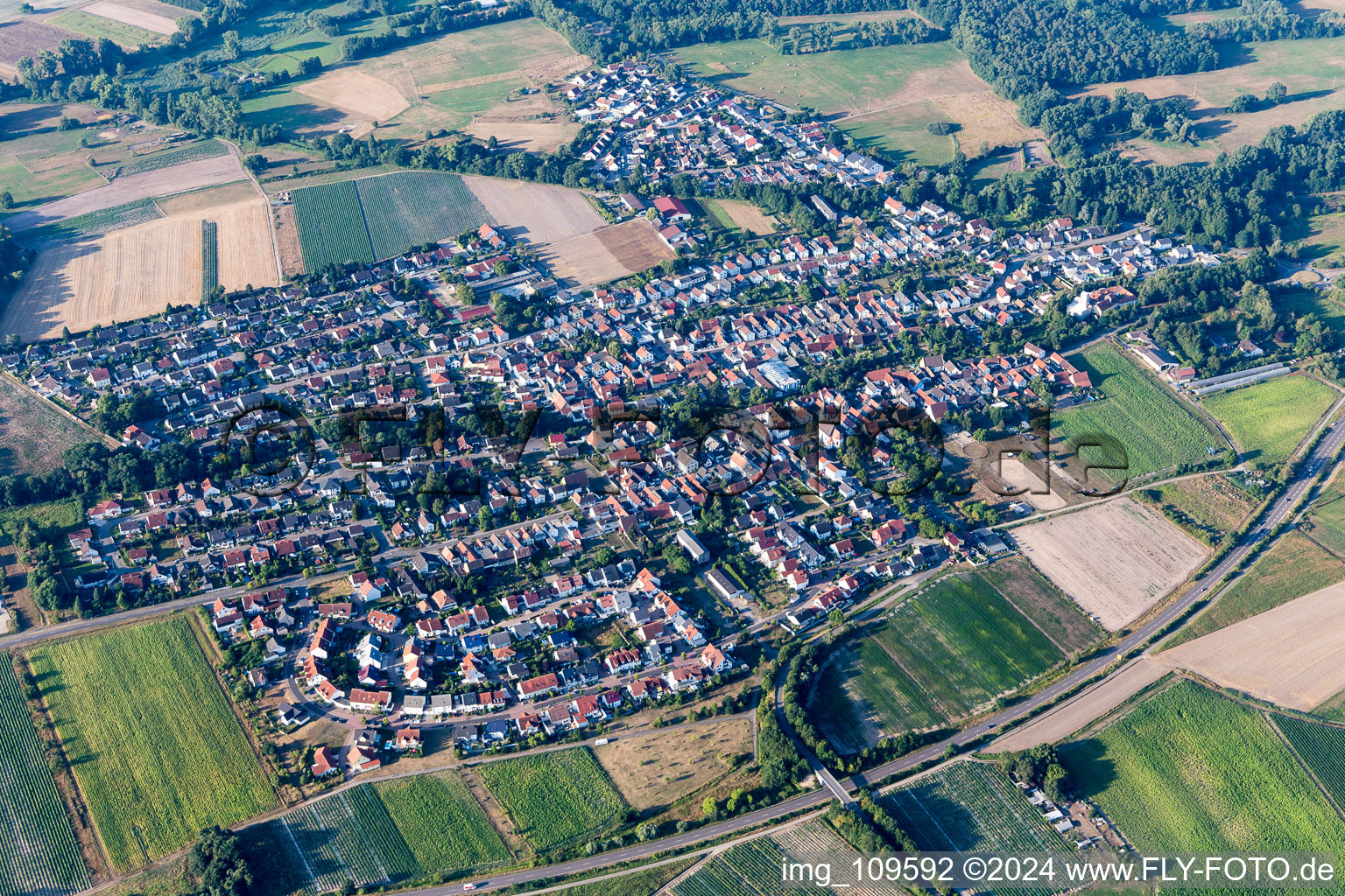 Aerial view of Agricultural land and field borders surround the settlement area of the village in Hanhofen in the state Rhineland-Palatinate, Germany