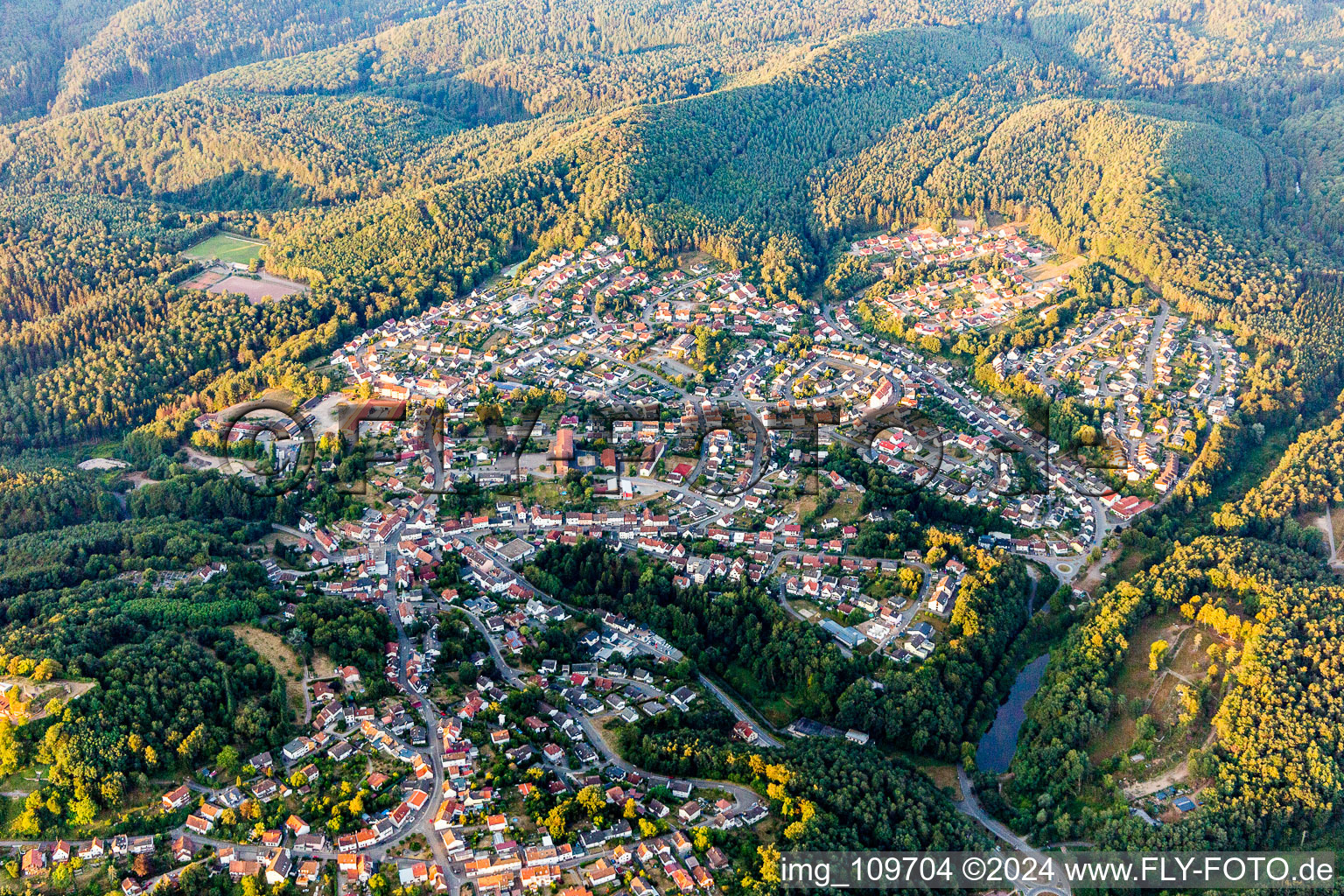 Location view of the streets and houses of residential areas in the valley landscape surrounded by mountains in Lemberg in the state Rhineland-Palatinate, Germany