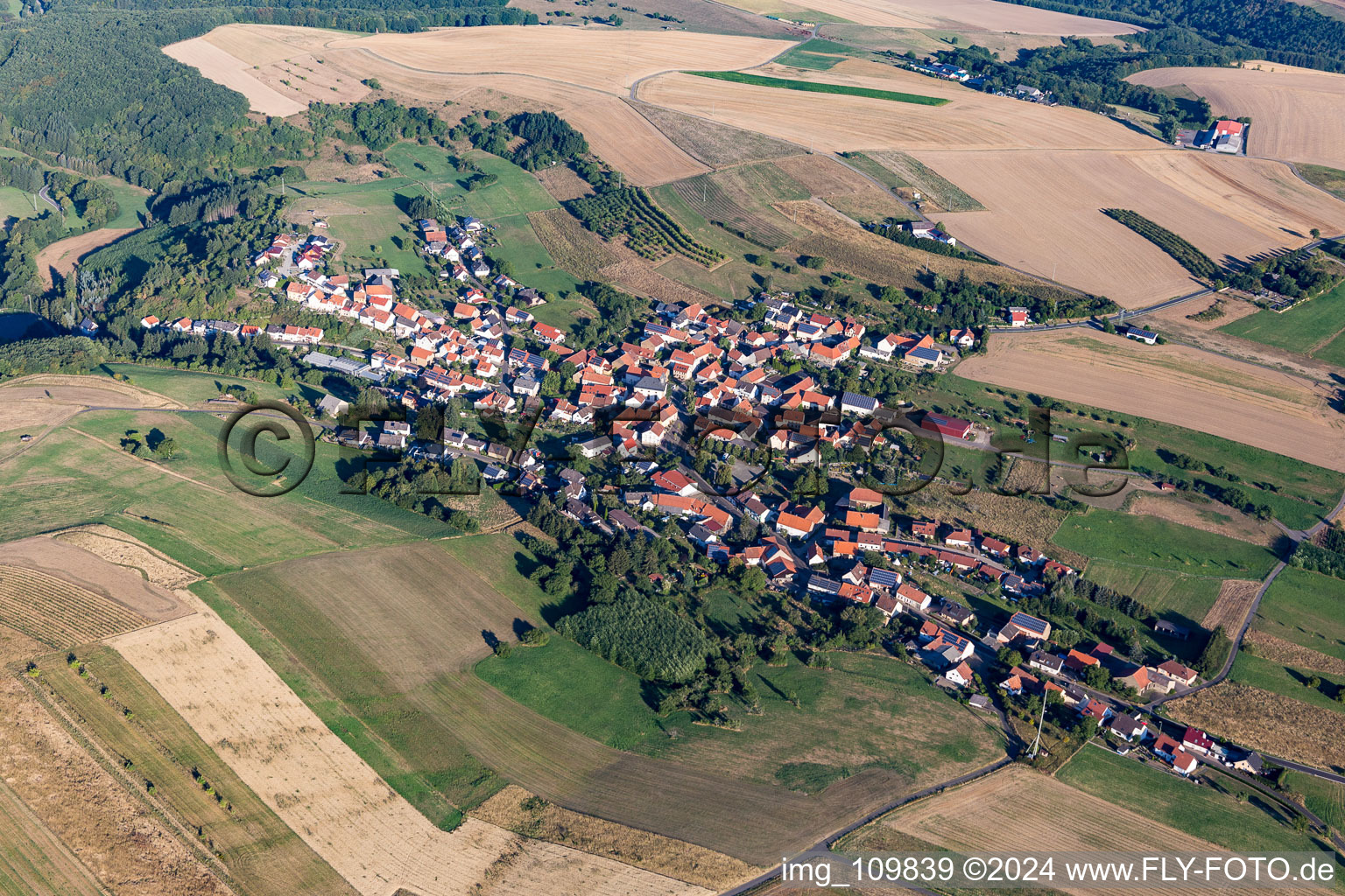 Agricultural land and field borders surround the settlement area of the village in Becherbach bei Meisenheim in the state Rhineland-Palatinate, Germany